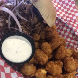 Pulled Pork Sammie with pickles, onions, and slaw piled on a Kaiser bun with Cajun tots and homemade ranch.