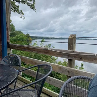 a table and chairs on a deck overlooking the water