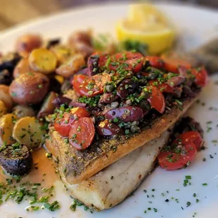 Pan-fried branzino fish with marble potatoes and cherry tomatoes