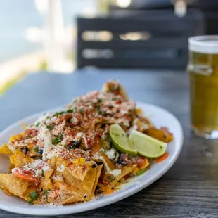 a plate of nachos and a glass of beer