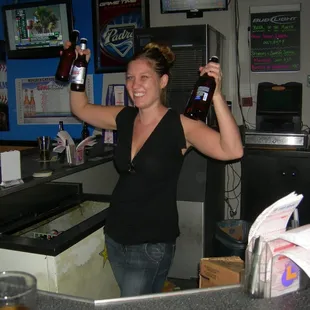 a woman holding two bottles of beer