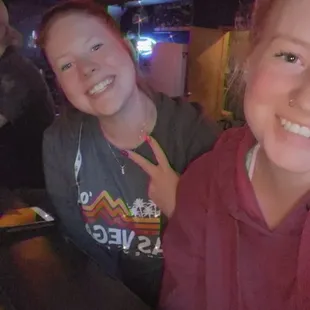 two girls sitting at a bar