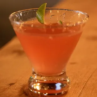 a drink in a glass with a lime garnish