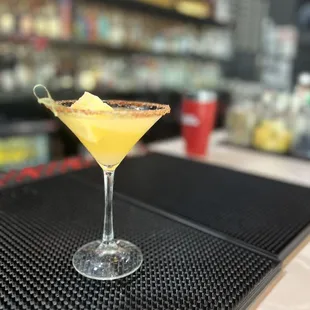 a cocktail in a martini glass on a bar