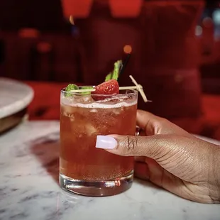 a person holding a glass of drink