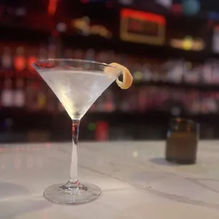 a martini in a martini glass on a bar counter