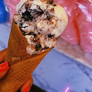 a hand holding a cone of ice cream