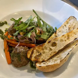 Lamb Meatballs $22 on a bed of ricotta, pesto, and arugula with grilled carrots, plus extra toasted bread.