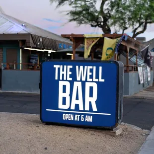 a blue sign on the sidewalk