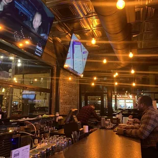 a man sitting at a bar watching tv