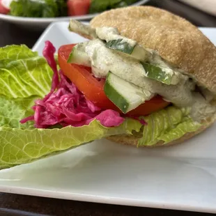 a sandwich with lettuce, tomato and cucumber