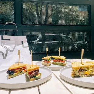 two plates of sandwiches on a table