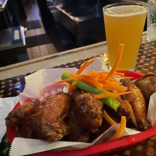 a basket of wings and a glass of beer