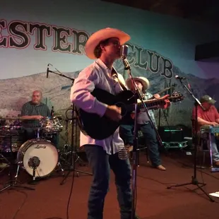 a man in a cowboy hat playing guitar