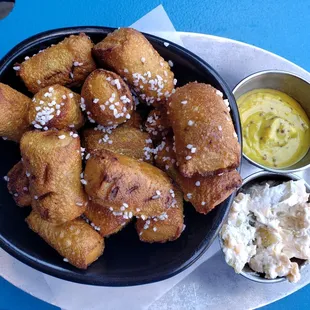 a plate of fried food with a side of mustard