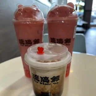 Two large strawberry slushes with strawberry popping boba and one crème brûlée brown sugar milk with boba.
