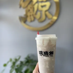a hand holding a cup of iced coffee