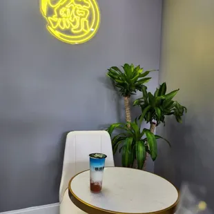 a table and chairs in front of a neon sign