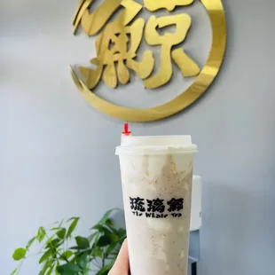 a hand holding a cup of milk tea