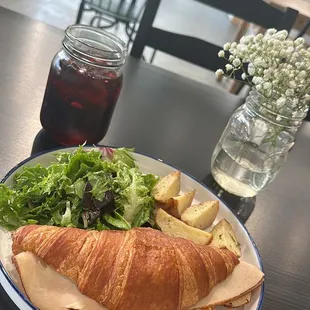 a croissant sandwich and salad