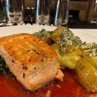 Pan Seared Salmon, sautéed Spinach, and smashed Yukon Gold Potatoes in a light tomato broth.