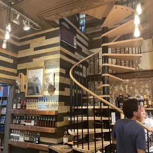 a man standing in front of a spiral staircase