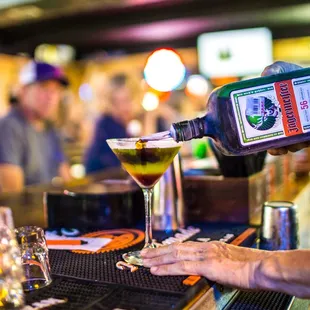 a bartender pouring a drink