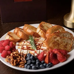 Try our Baked Brie! House Made Hot Honey, Raspberries, Strawberries, Blueberries, and Candied Walnuts with Toasted Crostini Bread