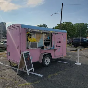 a pink food truck parked in a parking lot