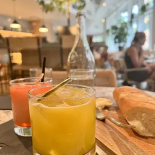 a glass of orange juice and a loaf of bread