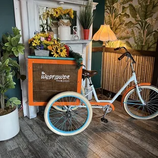 a bicycle parked in front of a flower shop
