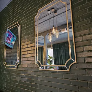 three mirrors on a brick wall
