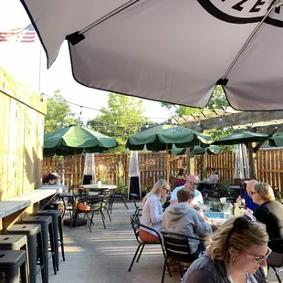 people sitting at tables under umbrellas