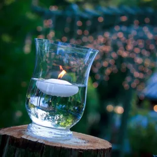 a lit candle in a glass vase