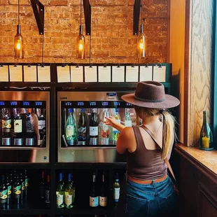 a woman standing in front of a wine cooler