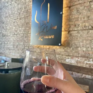a hand holding a glass of wine