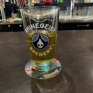 a glass of beer on a bar