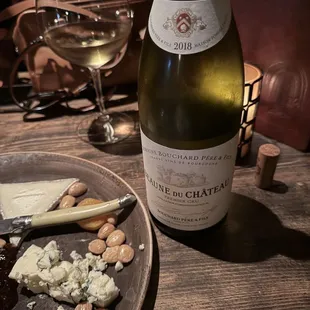 a plate of cheese, crackers, and a bottle of wine