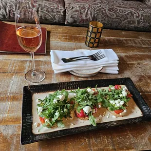 Mediterranean Toast: overly crispy toast hummus spread on toasted cracked wheat bread, w/red piquillo peppers, arugla + feta cheese.