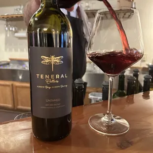 a person pouring a glass of wine