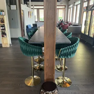a long table with green velvet chairs