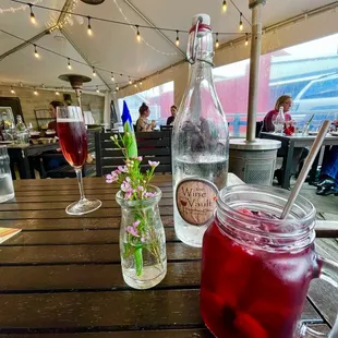 a glass of wine and a jar of ice tea