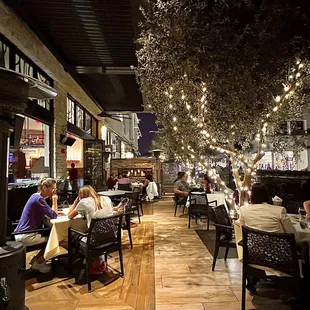 Outdoor patio with heated lamps and lit up trees.