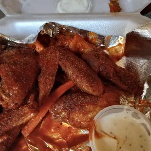 a tray of chicken wings with sauce