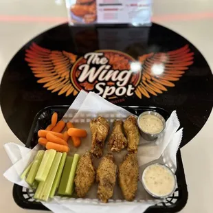 a tray of wings, carrots, celery, and celery sticks
