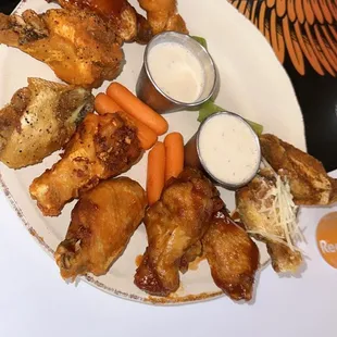 a plate of chicken wings and carrots