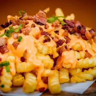 a pile of fries covered in cheese and bacon