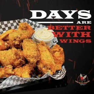 a basket of chicken wings with dipping sauce