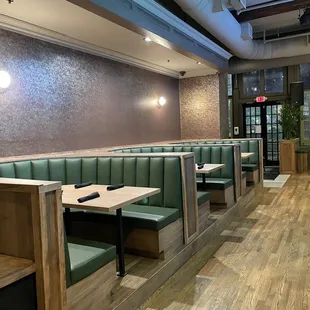 an empty restaurant with green booths