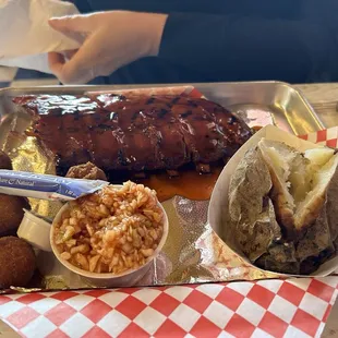 The half a rack of ribs plate with baked potato and coleslaw